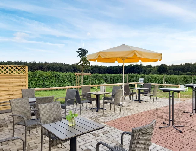Terrasse beim Himbeerglück mit Sonnenschirm, Tischen und Stühlen
